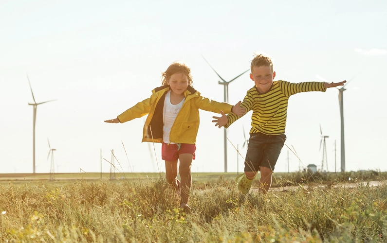 Kids playing next to wind turbines