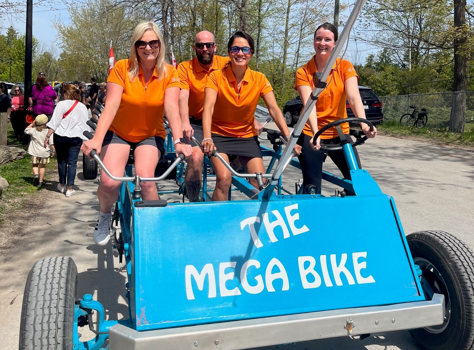 Image - Group Photo - Employees are riding a bike